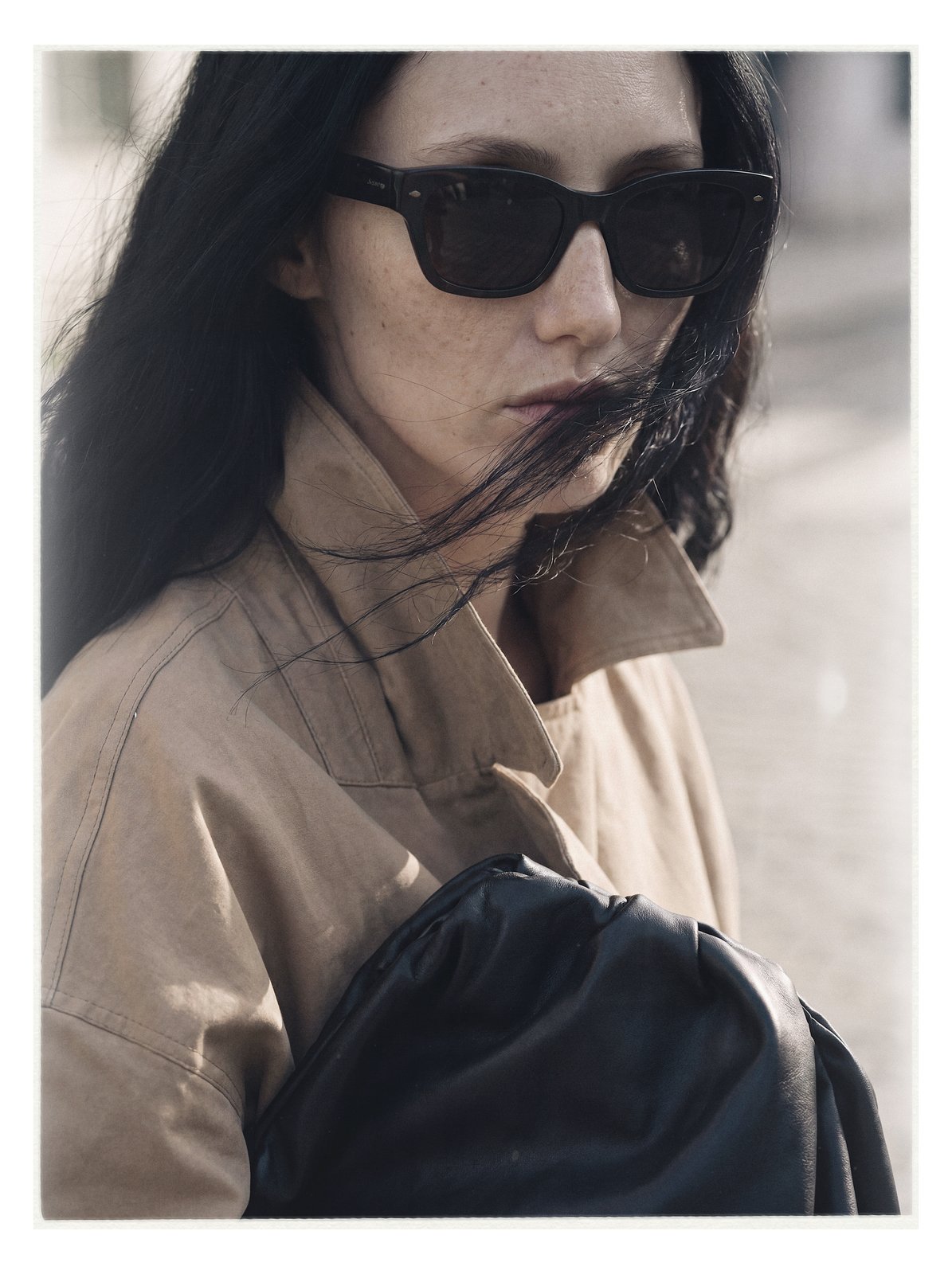 Street editorial: wind-blown close portrait in sunglasses